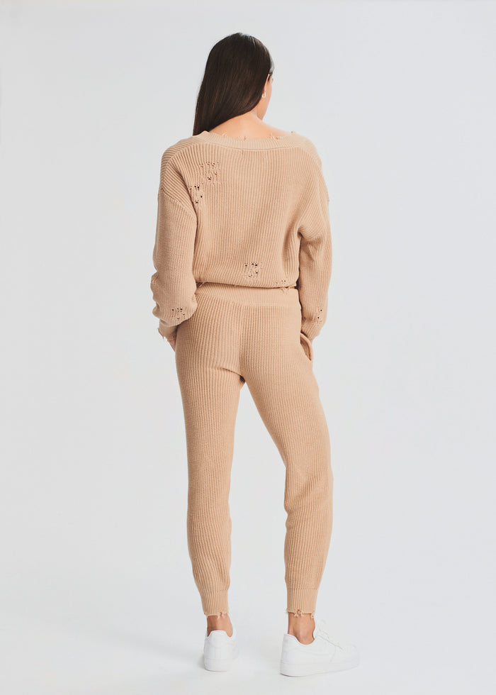 Back view of a model wearing a beige Ida Jogger knit set with a cropped sweater and joggers. media 3 of 4