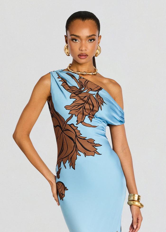 Model wearing a sky blue one-shoulder maxi dress with large brown botanical print. media 5 of 5