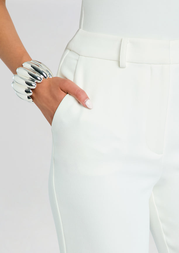 White Eira Pant close up at the hip with hand in pocket and a chunky silver bracelet