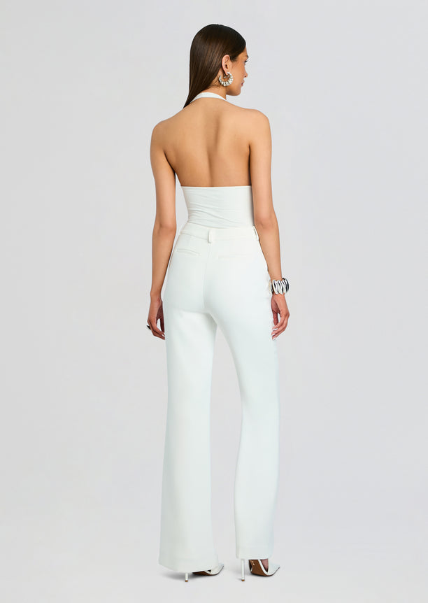 Back view of model in pale Eira Pant with halter neck top showing high waist and back pockets