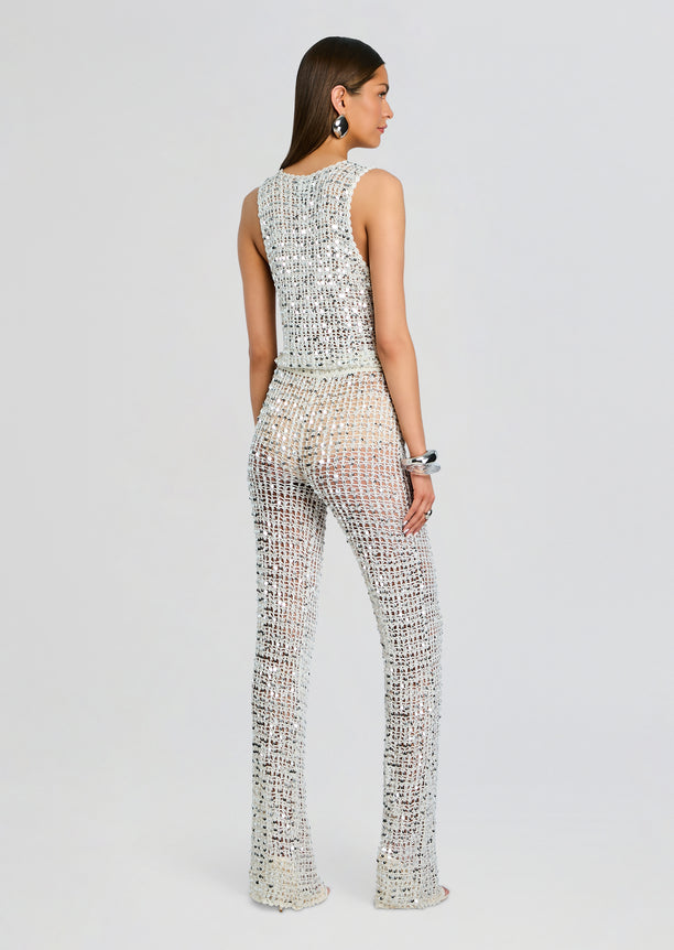 Back view of Nirvana Sequin Crochet Jumpsuit on model showing sleeveless silver crochet top and wide sequined pants