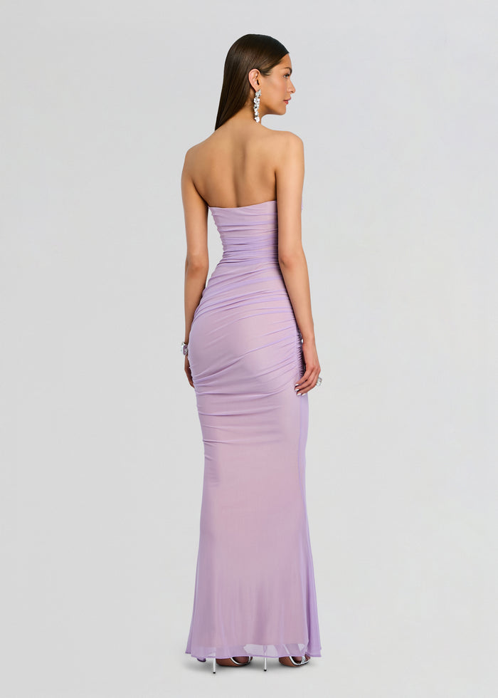 Back view of a model in Quintessa Mesh Dress lavender with a strapless bodice and crocheted mesh panels at the waist and a sheer hem. media 4 of 5