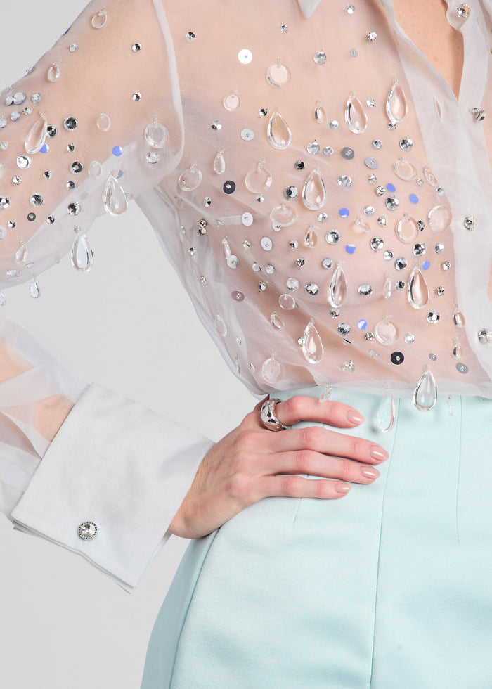 Detail shot of the Eugenia Embellished Blouse sleeve densely adorned with crystals on sheer fabric, paired with a mint skirt media 3 of 6