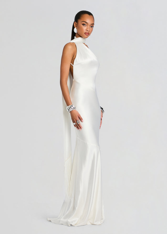 Kelsa Dress on a model in ivory satin halter neck with open back and tasseled fringe at the hem media 4 of 5