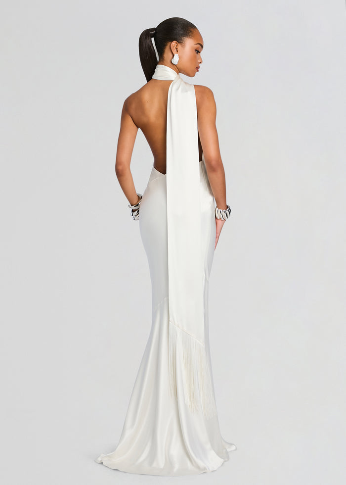 Back view of a white Kelsa Dress with halter neckline and long draped back scarf, satin gown with fringe at the hem. media 1 of 5