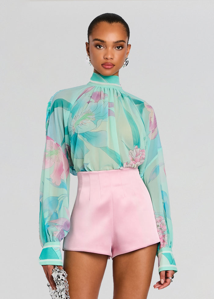 Model wearing Olympia Top in pastel turquoise floral print with a high neckline and billowy long sleeves. media 1 of 7