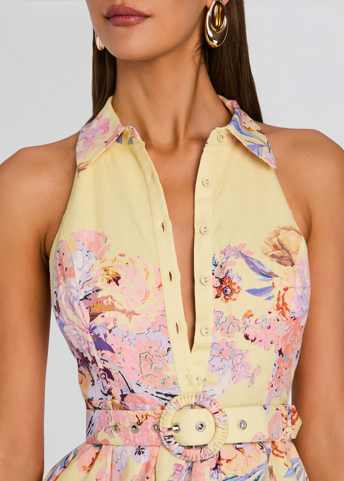 Close-up of a pale yellow floral dress bodice with a placket and a round belt buckle at the waist. media 2 of 5