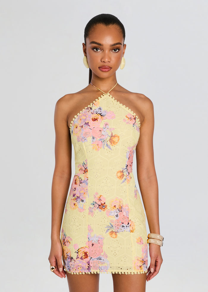 Front view of a model wearing the Kysha Short Dress in pale yellow with pink and purple floral print and a halter neckline media 5 of 5