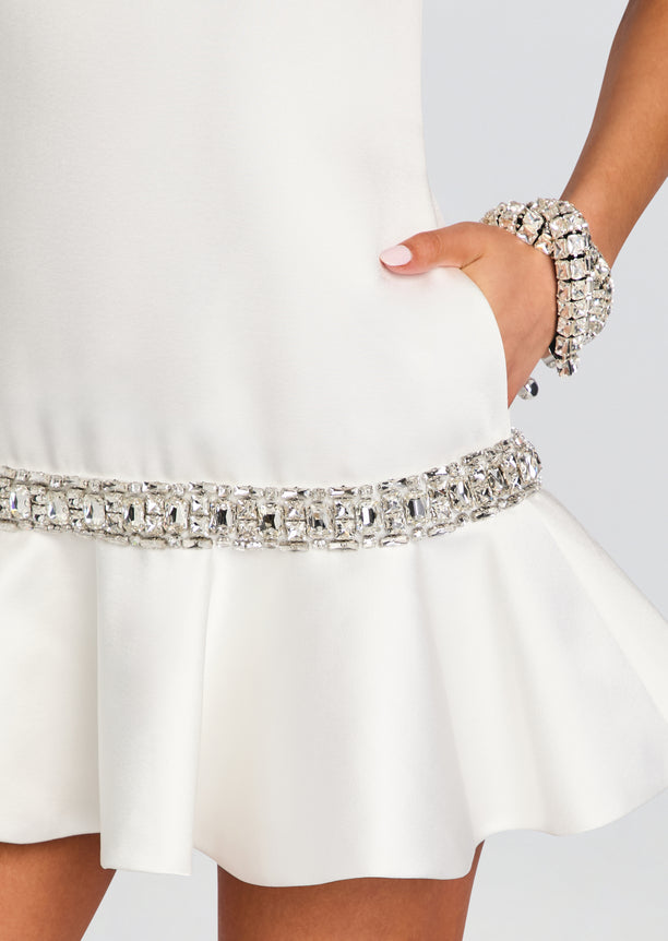 Close up of the Caelie dress at the waist showing the crystal belt and a hand resting in the side pocket