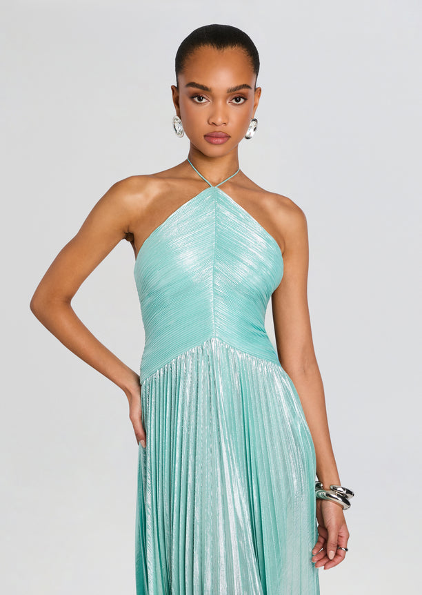 Model in mint green metallic halter neck dress with a ruched bodice and pleated skirt