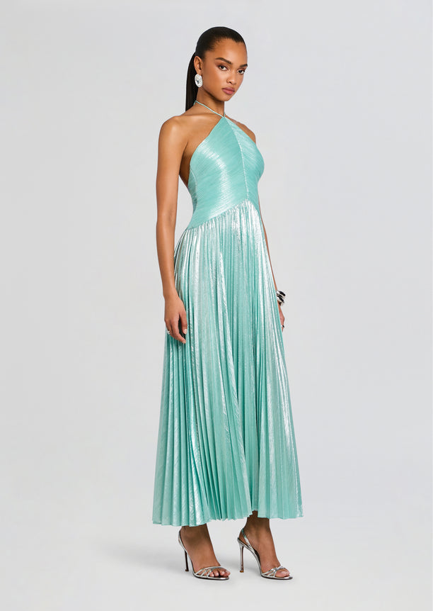 Full-length model wearing the turquoise Ivee Dress with a halter neckline and metallic pleated skirt