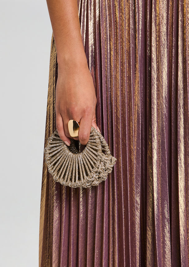 Jaya Mini Bag circular beaded clutch held in hand against a metallic pleated dress
