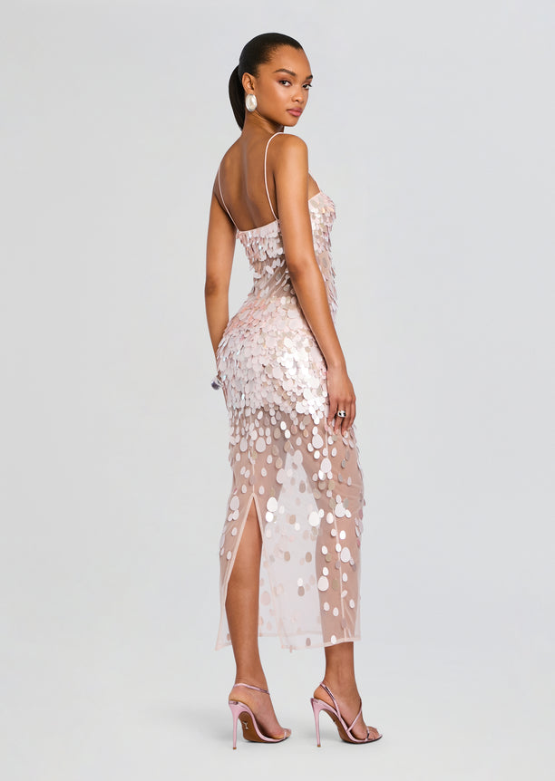 Back view of a blush pink Mischa Sequin Dress with circular sequins, a sheer overlay, and a thigh-high slit.