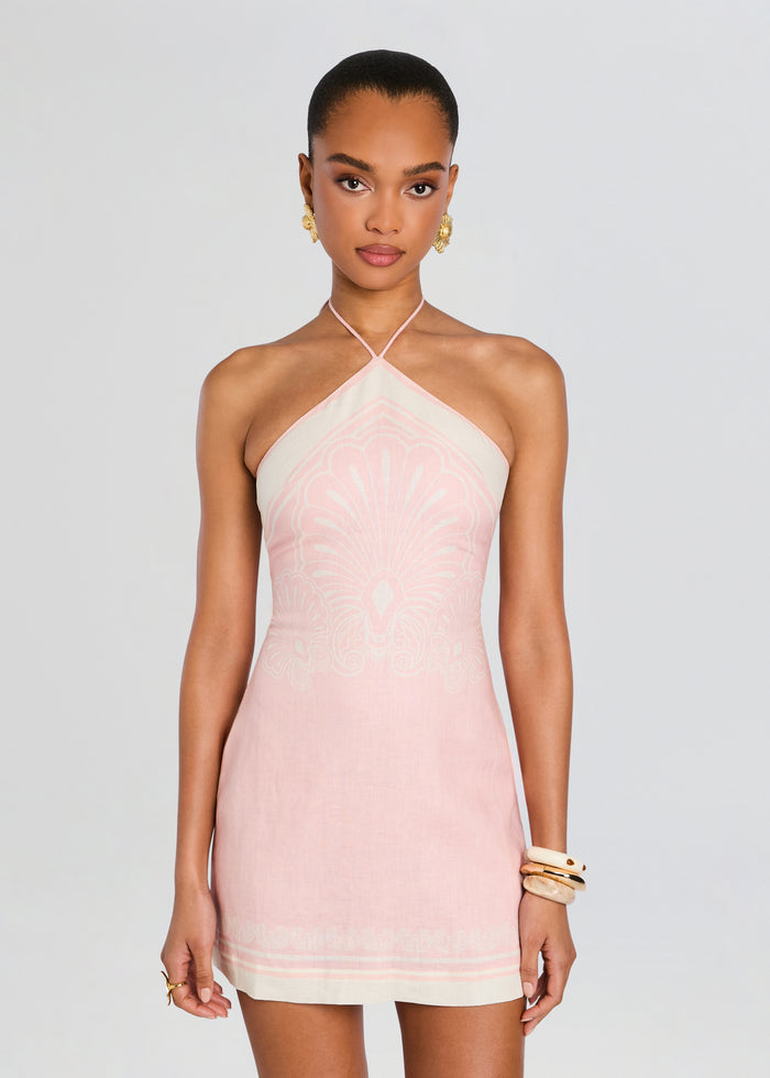 Front view of a model wearing a pale pink linen mini dress with a halter neckline and delicate white pattern media 5 of 5
