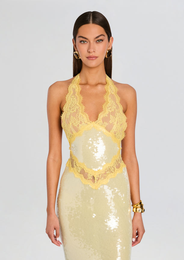 Front view of a pale yellow sequin dress with intricate lace trim and halter neckline