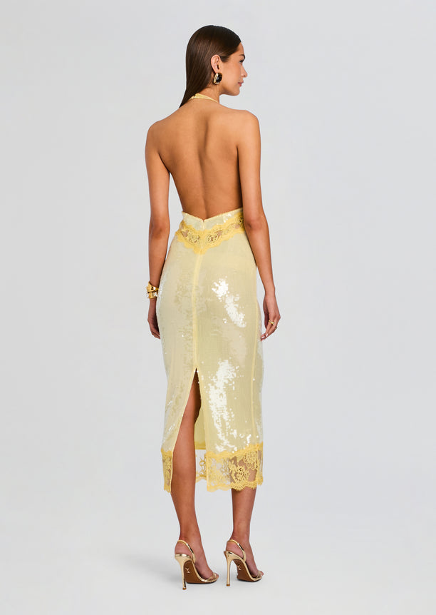 Back view of a pale yellow sequin lace dress with a low back and scalloped lace waistband