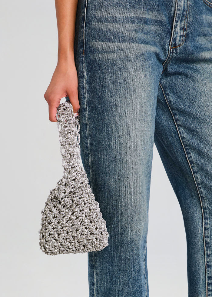 Person in denim jeans holding a silver crystal Niky Bag with a chunky beaded handle media 2 of 4
