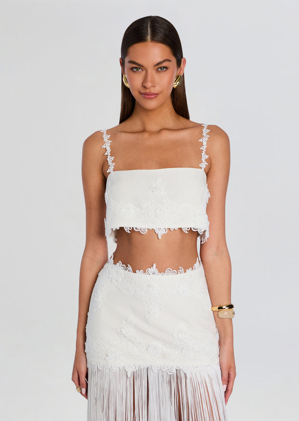 White lace cropped top with delicate floral straps and scalloped hem.