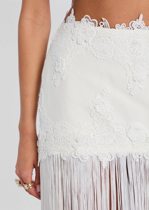 Amaris Skirt close up of white lace with floral appliqués and fringe hem