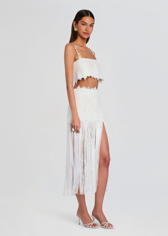 White lace crop top with delicate floral trim paired with a long fringe skirt on a model media 4 of 5