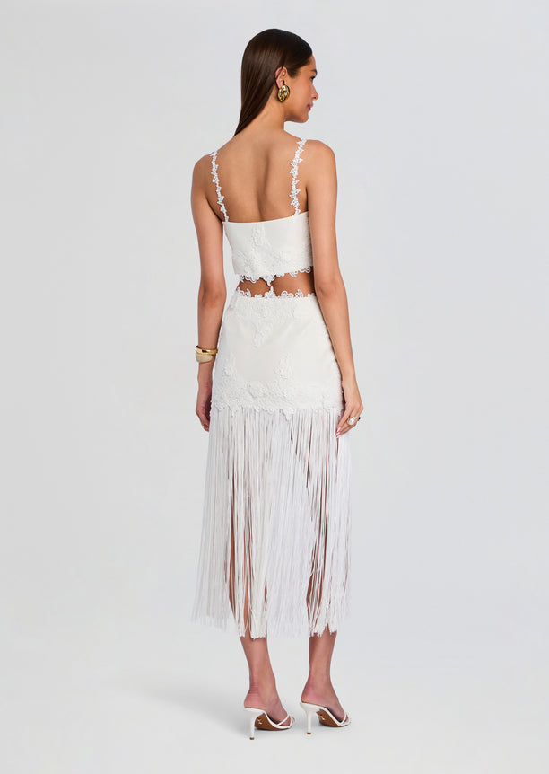 Back view of the white lace two piece with floral edges and a long fringe skirt on a model