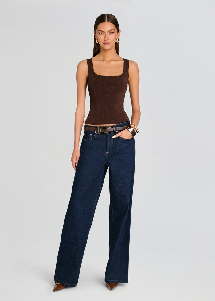 Woman wearing a brown tank top and blue jeans on a light gray background media 2 of 5
