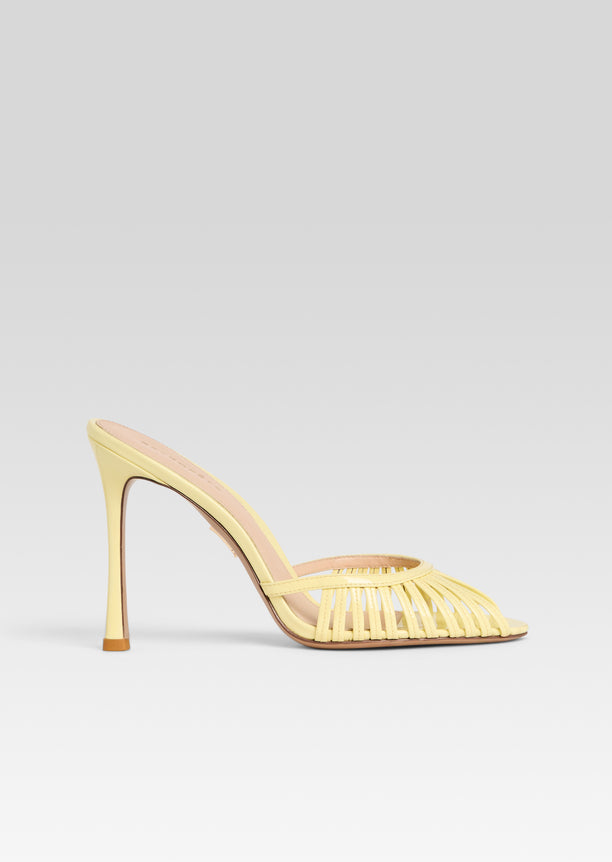 Allistair Sandal in pale yellow with woven toe straps and a slender heel seen from the side