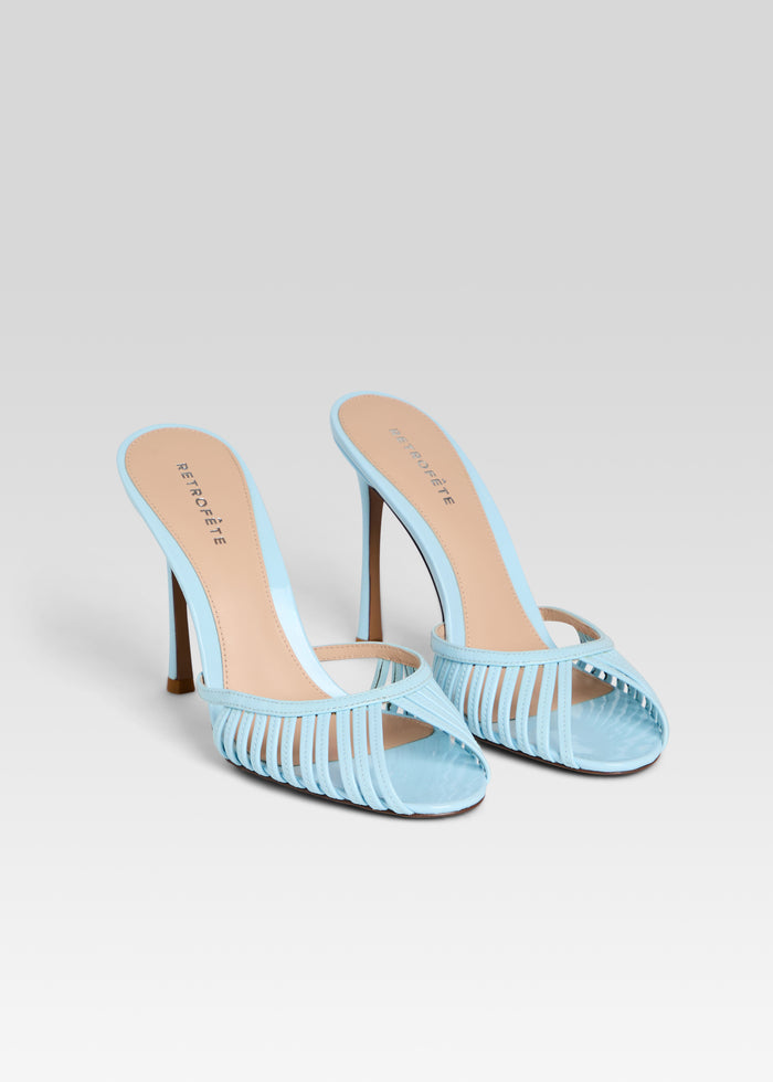 Pair of light blue strappy high heel sandals with thin heels on a white background. media 4 of 5