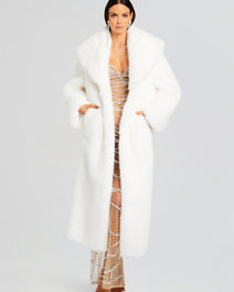 Model wearing the Averie Faux Fur Coat with a sparkling beaded gown underneath, hands in pockets.