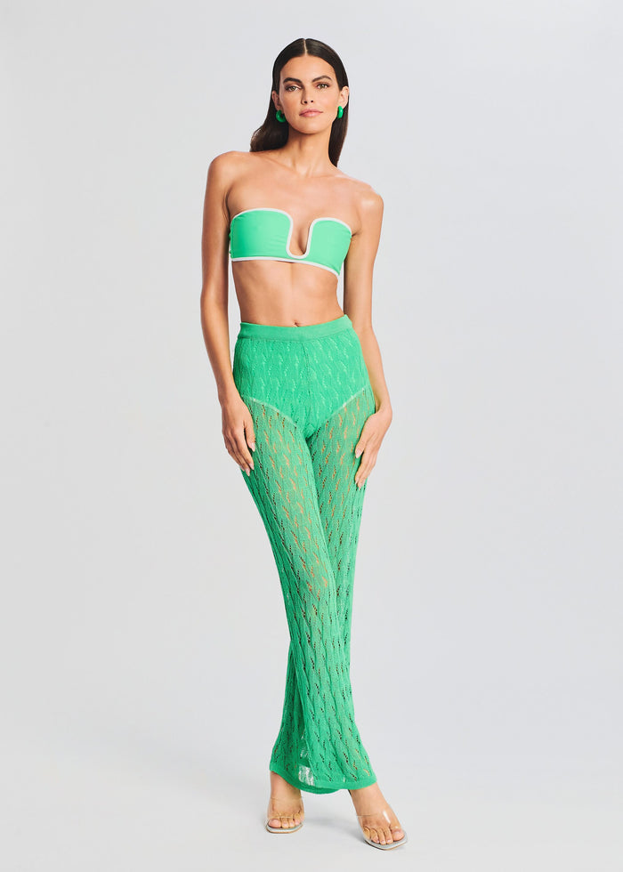 Front view of a model in a bright green bandeau top with white edging and matching knit long pants. media 5 of 5