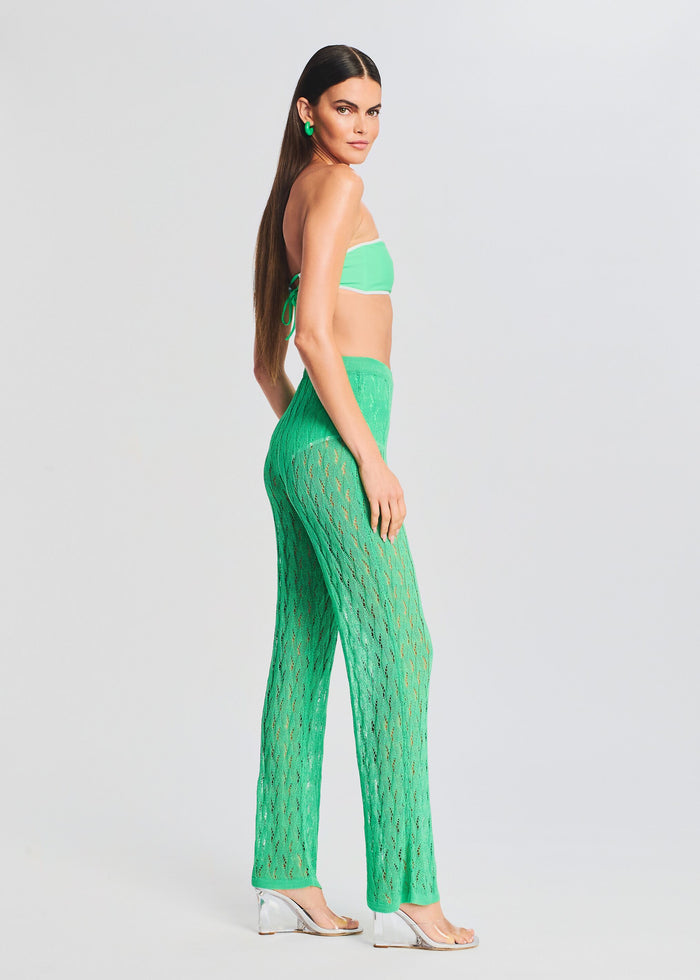 Side view of a model wearing neon green Dylan Knit Long Pant with an open knit pattern and a matching bandeau top. media 3 of 5