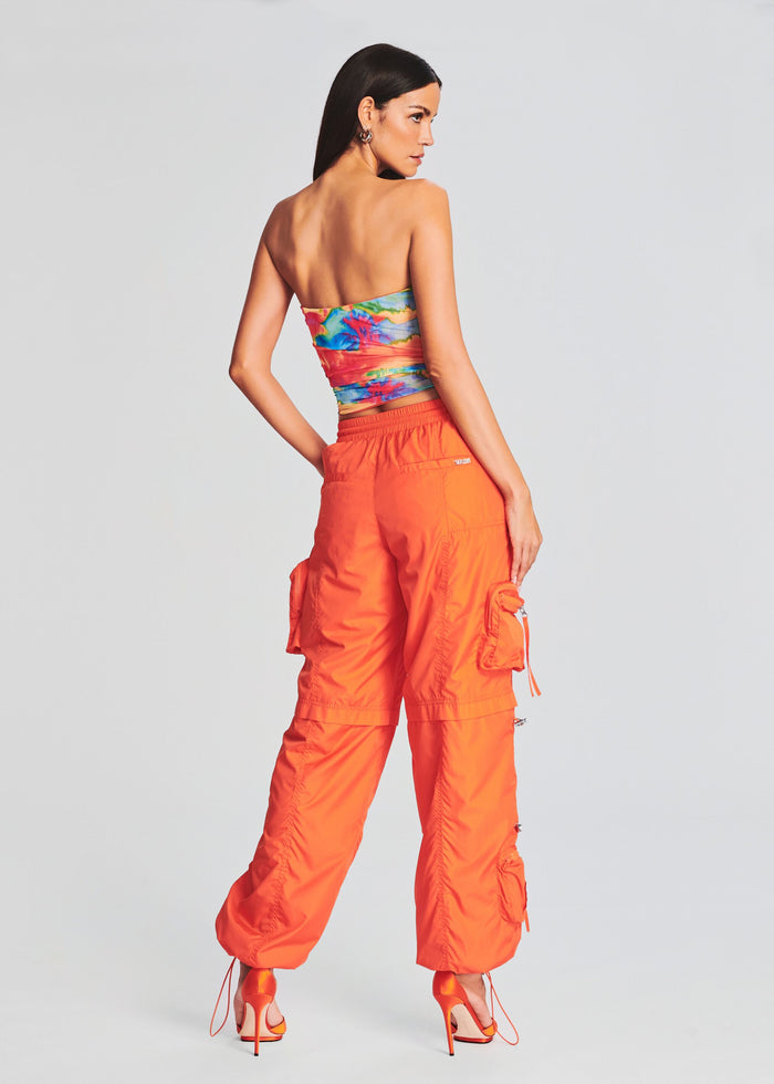 Back view of a model in a tropical print tube top and bright orange cargo pants. media 4 of 5