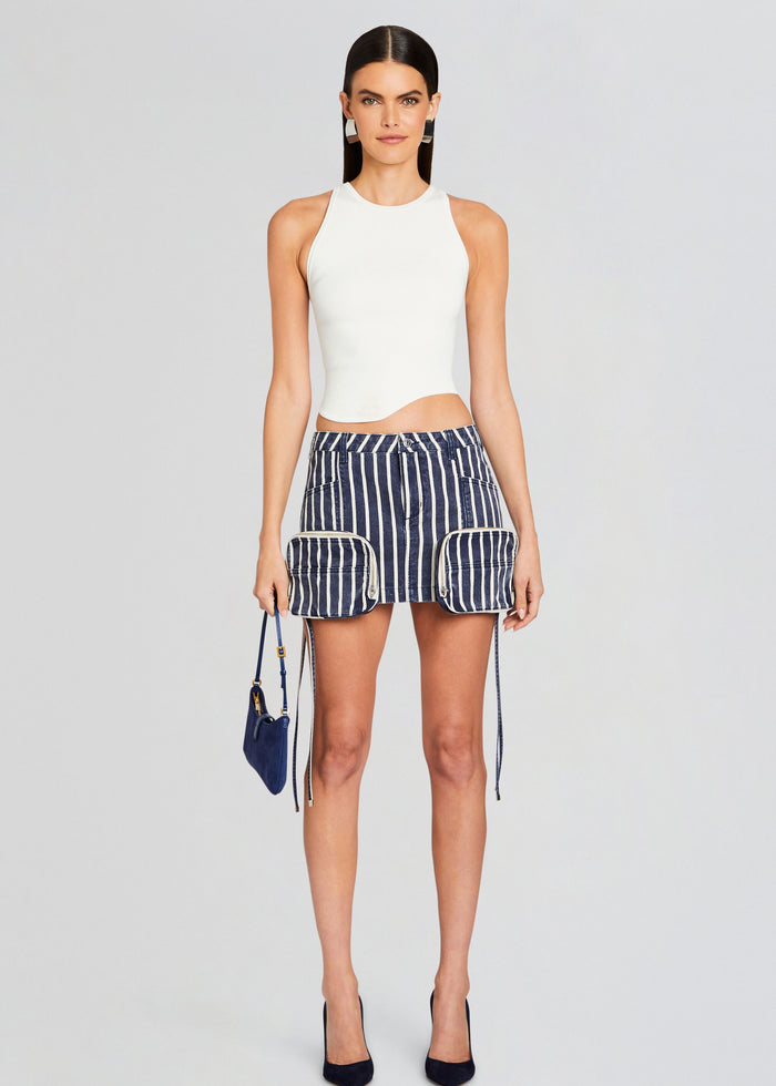 Model in navy striped cargo mini skirt with a white sleeveless top and a blue handbag. media 2 of 6