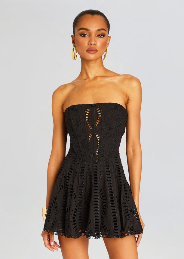 Front view of a model in a black strapless Zannick Short Dress featuring intricate eyelet cutouts and a fitted bodice.