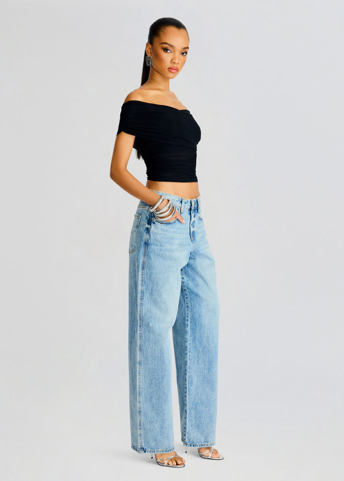 Side view of Aruba Mesh Top outfit with black off the shoulder crop top and light blue wide leg jeans. media 3 of 5