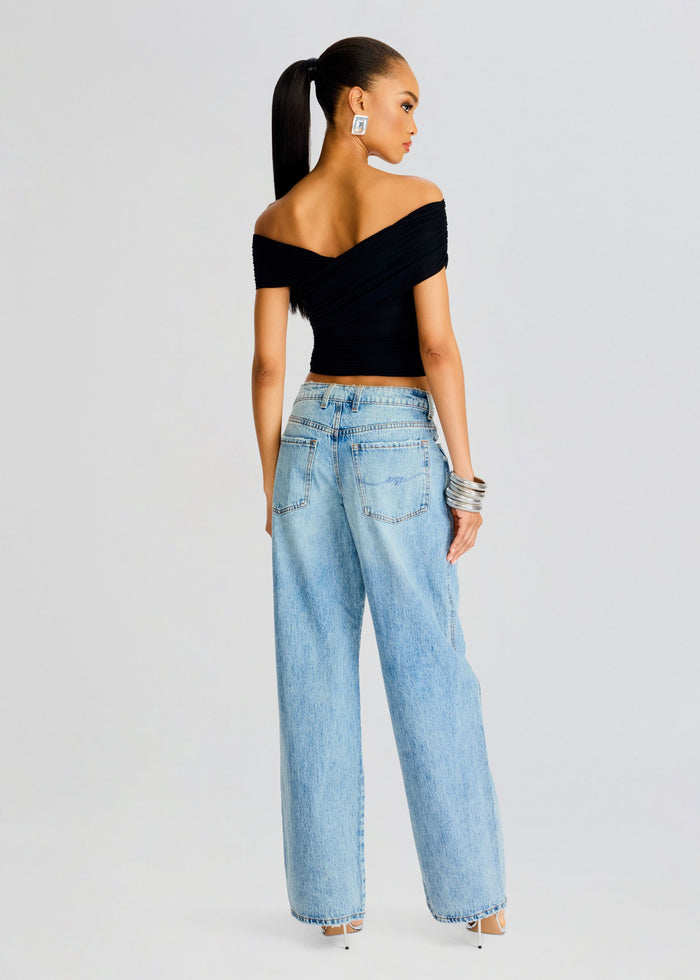 Rear view of a model wearing Aruba Mesh Top in black off-the-shoulder with light blue denim jeans. media 4 of 5