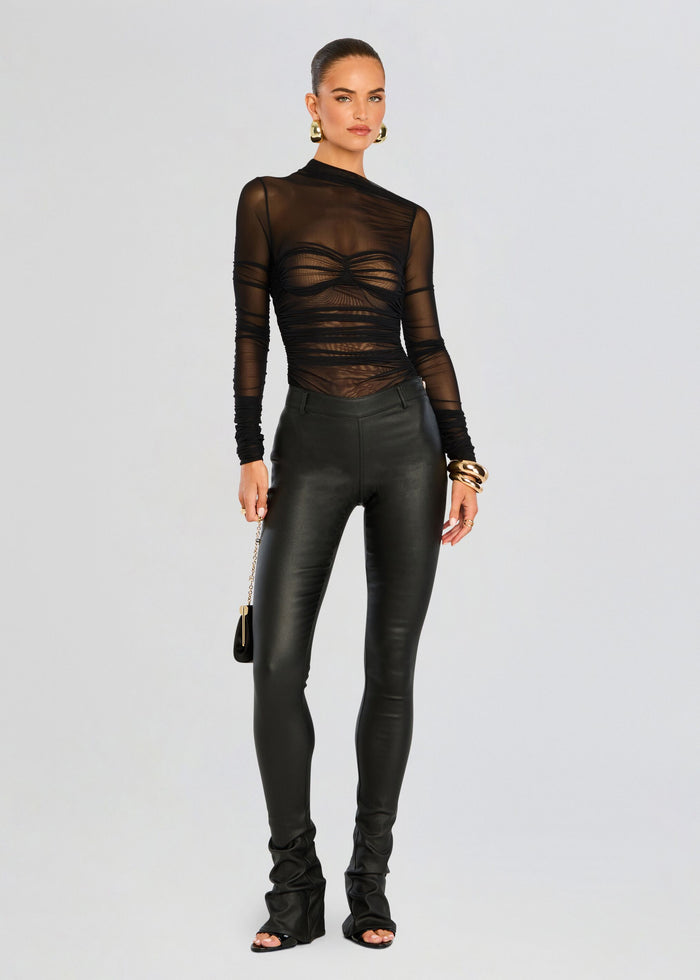 Model wearing black sheer Mila Ruched Bodysuit with asymmetric neckline paired with black leather pants. media 5 of 5