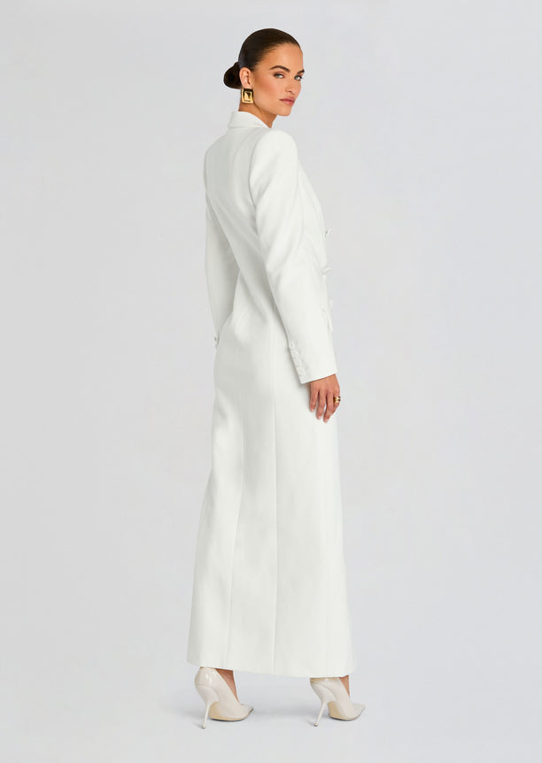 Side view of a model in a white Amberly Blazer Evening Dress with a long coat, highlighting the tailored silhouette.