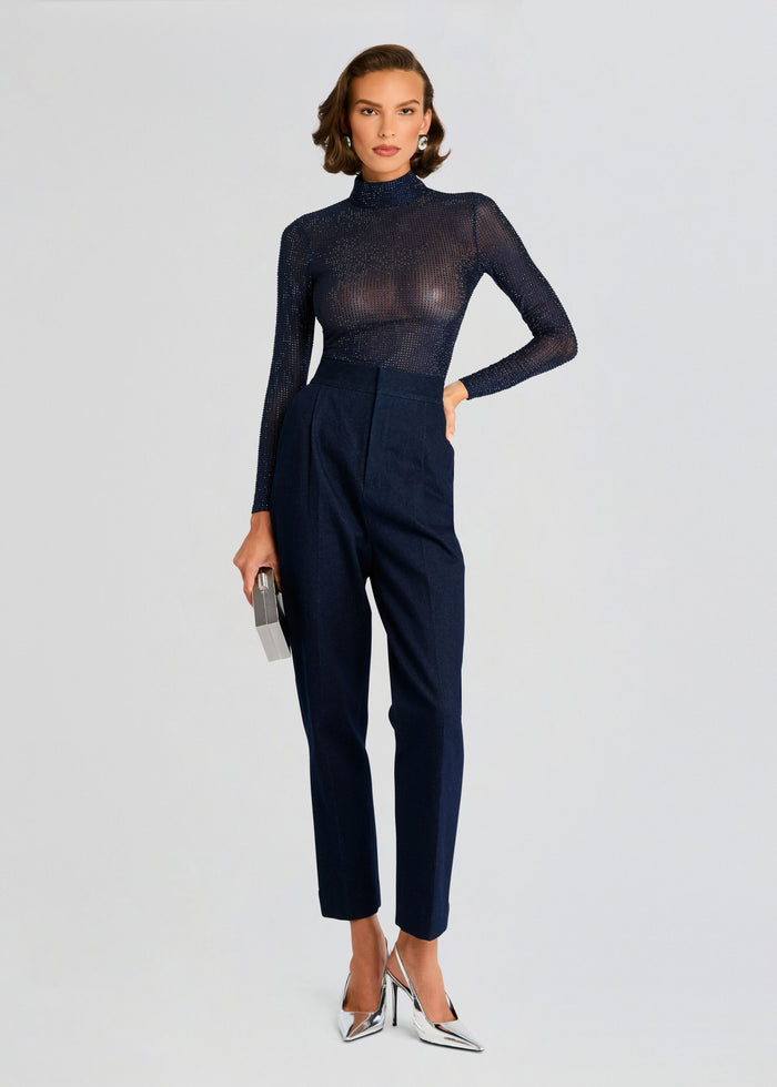 Model wearing Bronwyn Embellished Top in navy sheer with crystals, paired with high-waisted navy trousers and a silver clutch. media 5 of 5