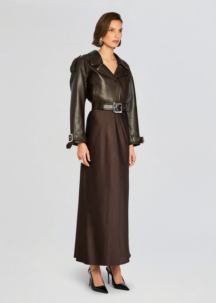 Model wearing the Einsley Leather Jacket with a belted waist and a long brown dress, black heels. media 3 of 5