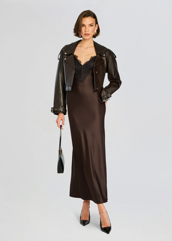 Model wears a cropped black leather jacket over a chocolate brown satin slip dress with lace neckline. media 5 of 5
