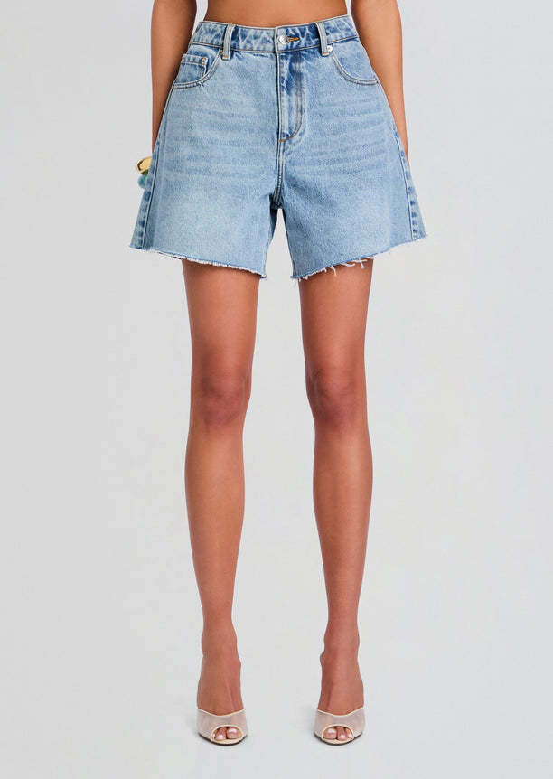 Front view of a model wearing light wash Sabrina Boyfriend Short denim shorts with a frayed hem