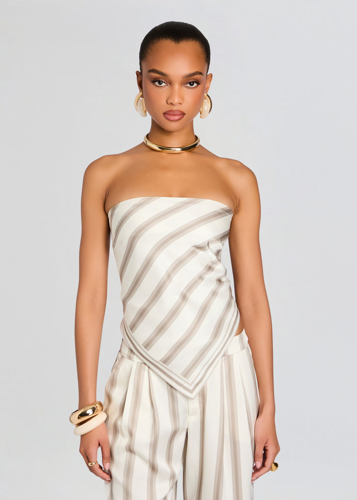 Model wearing Hark Satin Top in cream and taupe diagonal stripes with matching striped pants and gold accessories. media 1 of 5