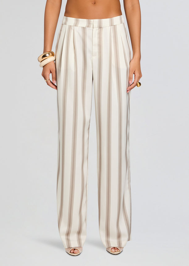 Model wearing Marlowe Satin Pant with high waist and wide-leg beige striped pants