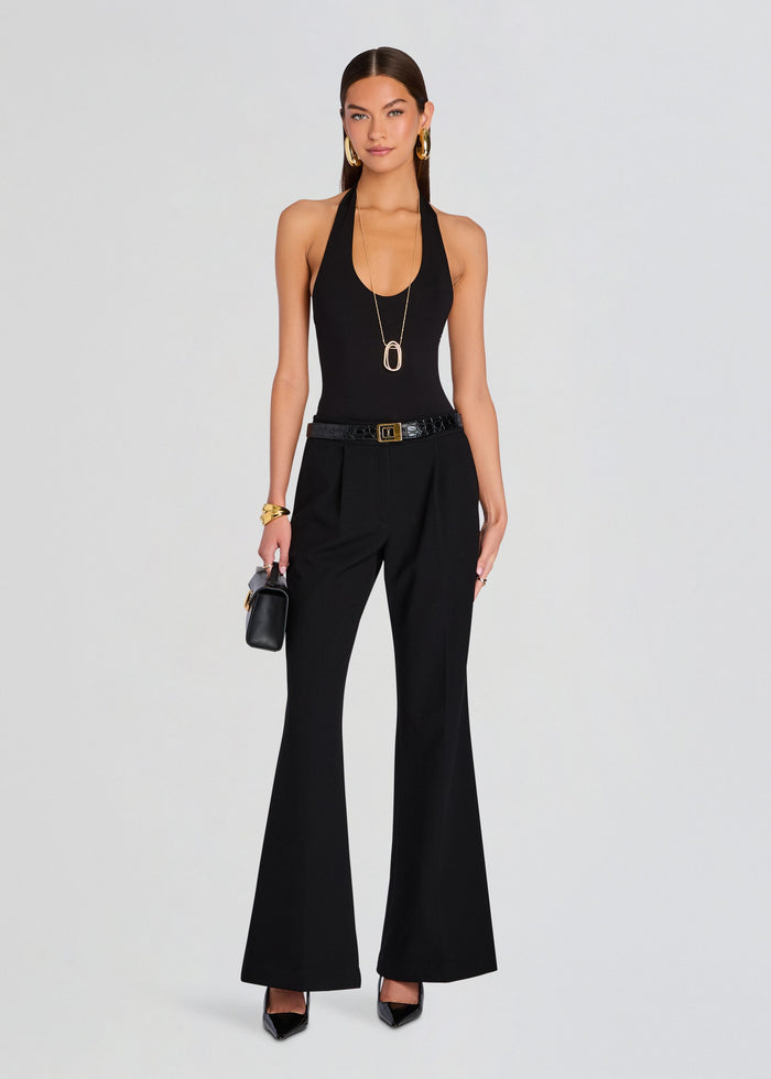 Full length model wearing a black Bamboo Halter Bodysuit with wide leg pants and a gold buckle belt. media 2 of 5