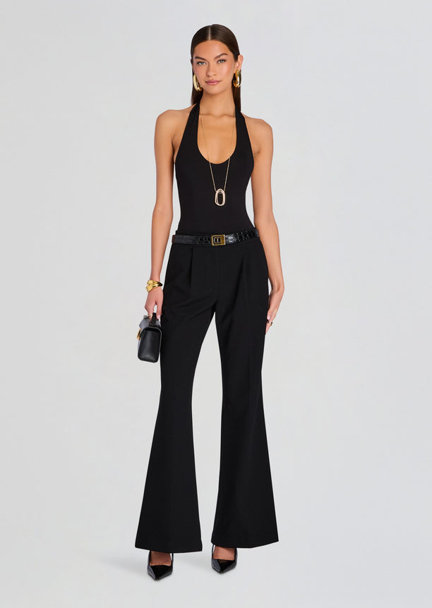 Full length model wearing a black Bamboo Halter Bodysuit with wide leg pants and a gold buckle belt.