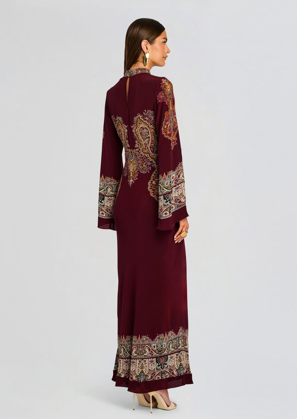 Back view of burgundy Shifa Long Dress showing paisley embroidery on the sleeves and decorative border along the hem.