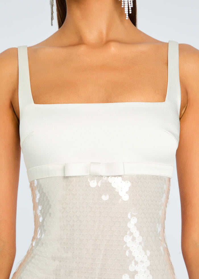 Close-up of the Yvaine Sequin Dress bodice showing a square neckline and wide straps over a pale sequined skirt. media 2 of 5