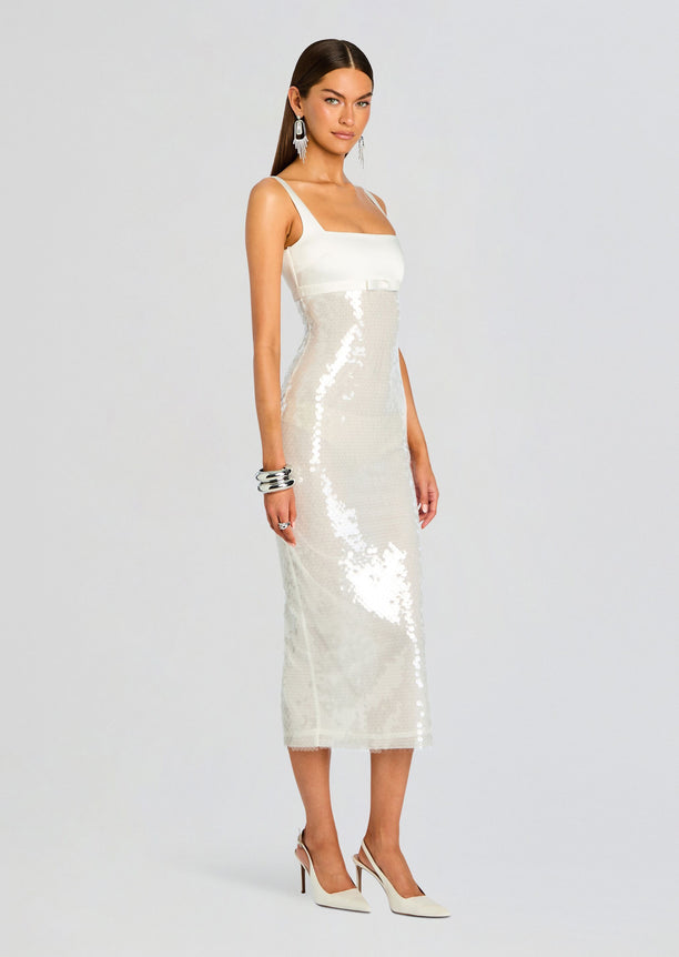Model wearing Yvaine Sequin Dress with white satin bodice and pale sequin midi skirt tied at the waist