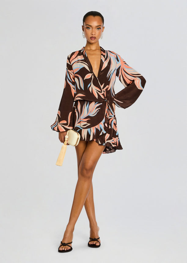 Model in brown tropical print wrap mini dress with deep V neck and belted waist.